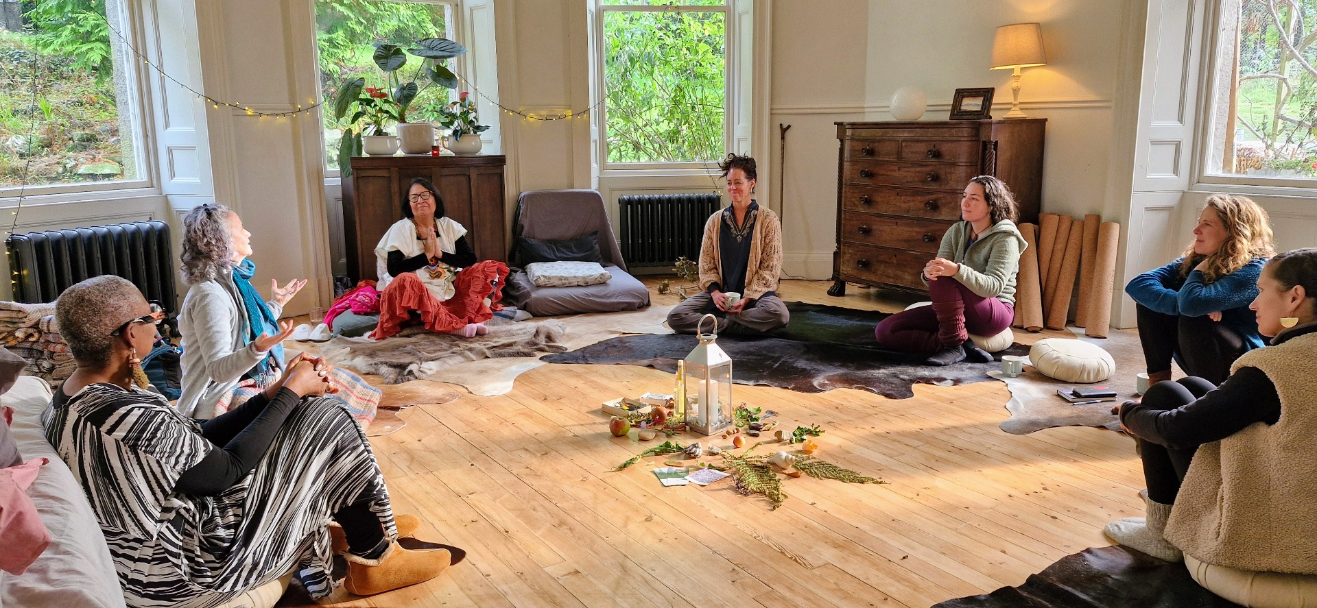 Women gathered in a candlelit circle indoors